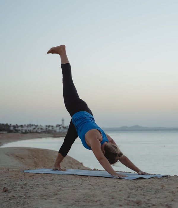 Woman in a peaceful yoga pose against a misty blue background.